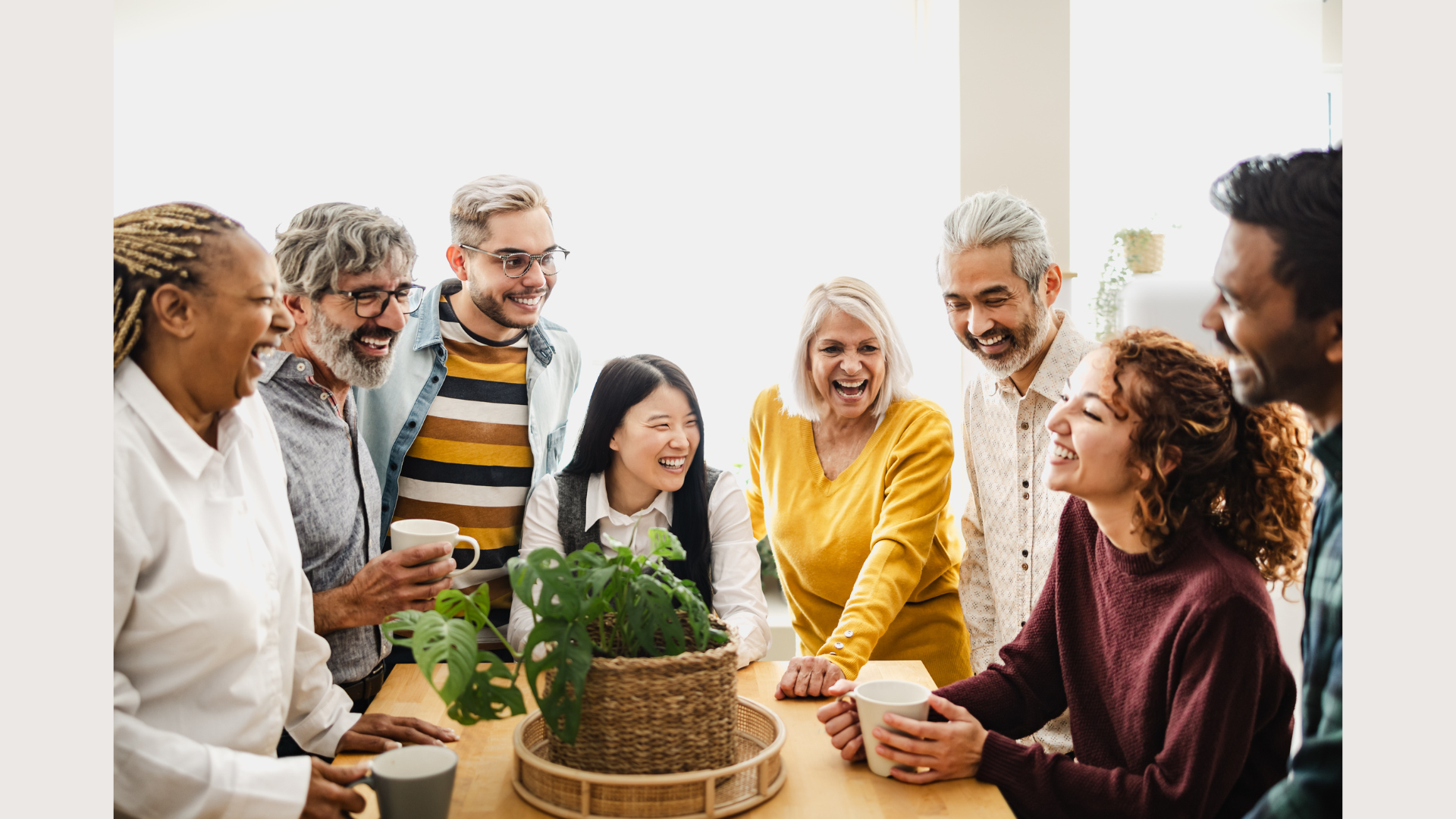 A joyful, multigenerational group laughing together around a table